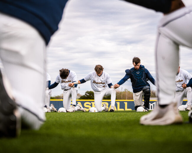 UCO's Baseball players meet to pray before the start of the game. (Hunter George/ The Vista)