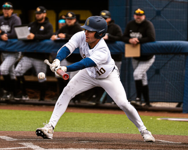 UCO's Colton Ayers goes for a bunt and gets it to move the player on base. (Hunter George/ The Vista)