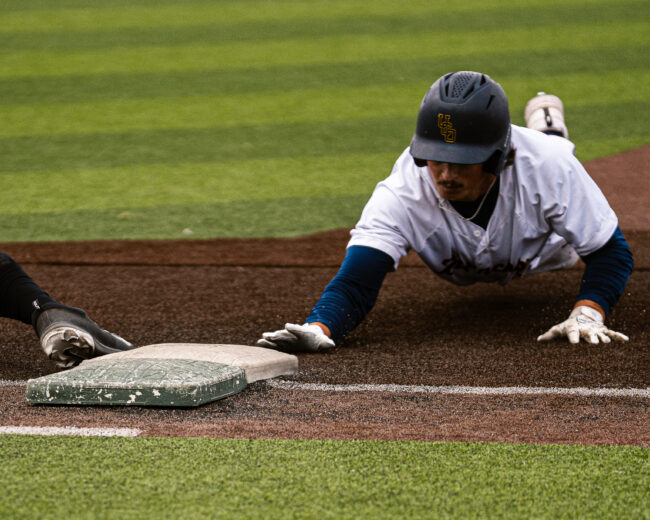 UCO's Wyatt Yetter slides back to first base before he can get thrown out. (Hunter George/ The Vista)