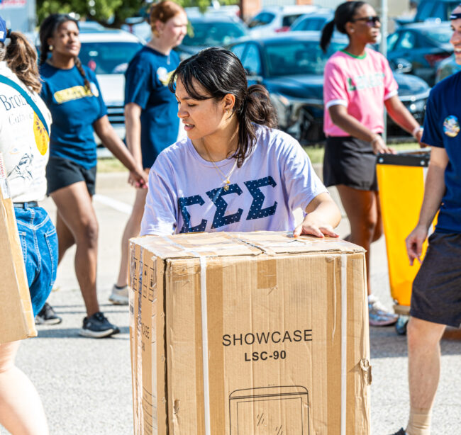 Tri Sigma volunteer prepares to move a box for a UCO student. (Drew Rayburn/ The Vista)