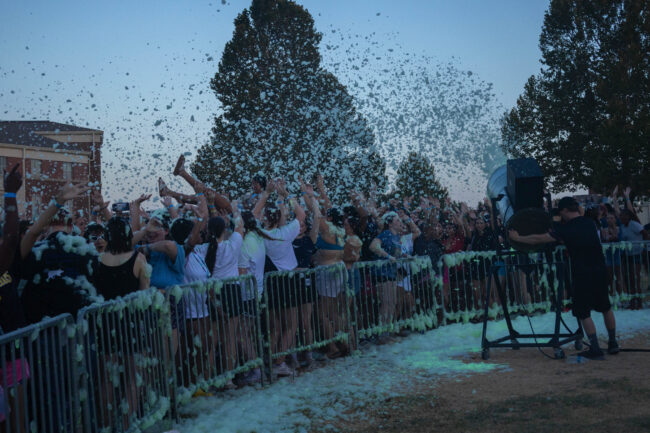 A student crowd surfs next to the barricades and party foam machine. (Maycee Elerick/The Vista)