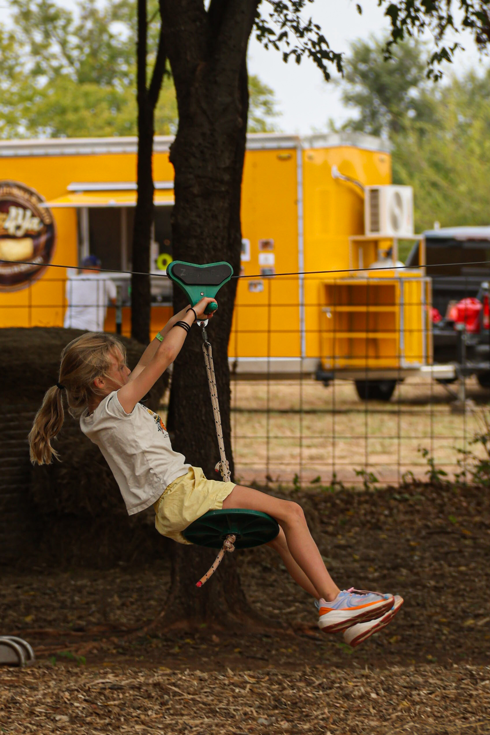 A little girl rides the zipline at the festival. (Emily Lavarn/The Vista)
