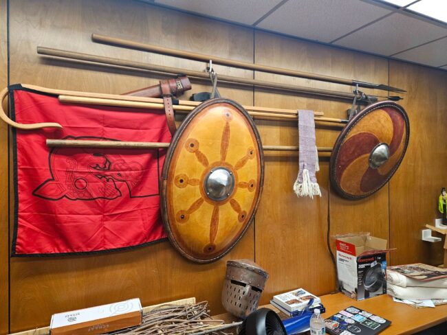Medieval weapons and props are displayed along the walls at the UCO medieval society meeting room.