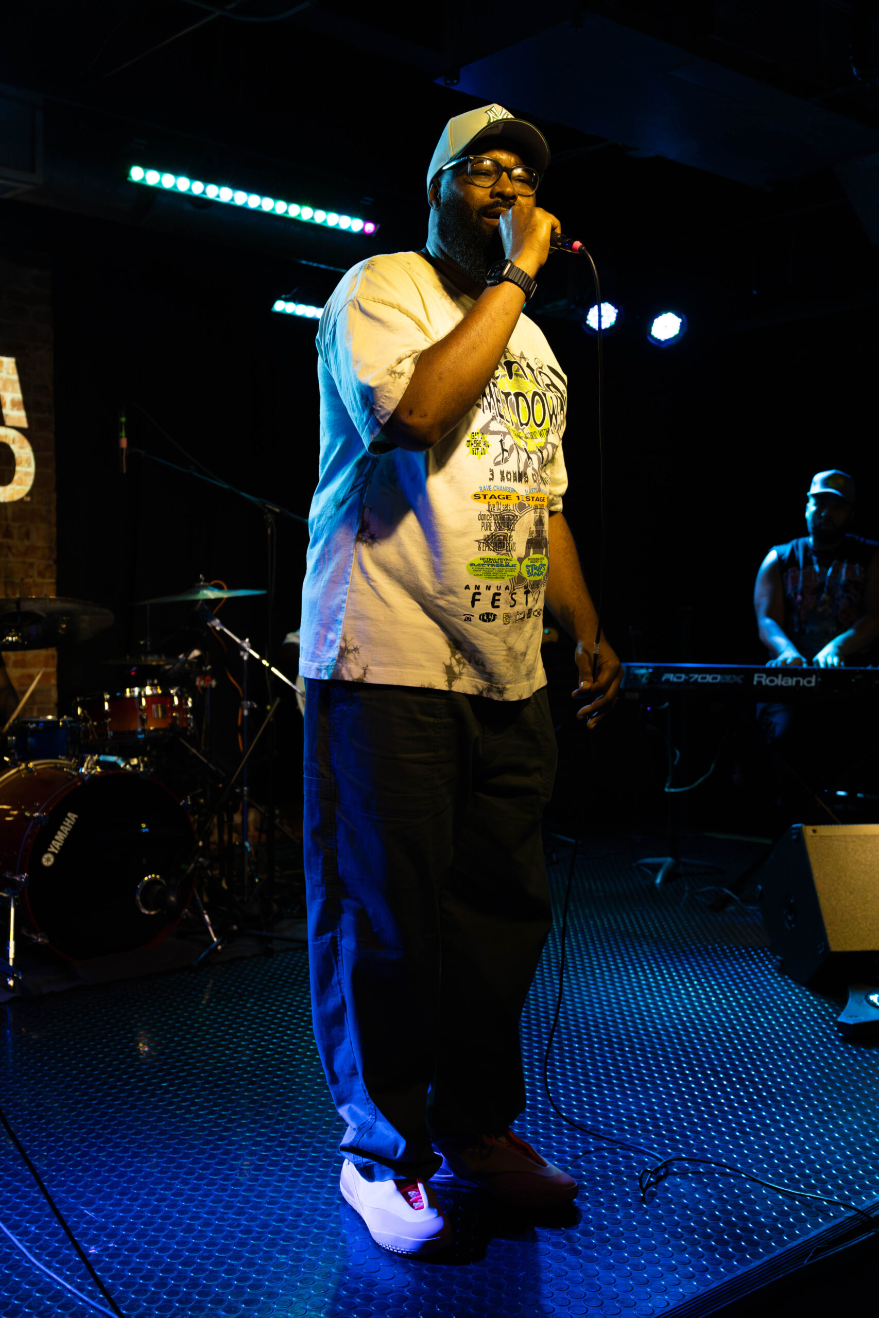 Tony Foster Jr. stands at edge of stage holding microphone.(Maycee Elerick/The Vista)