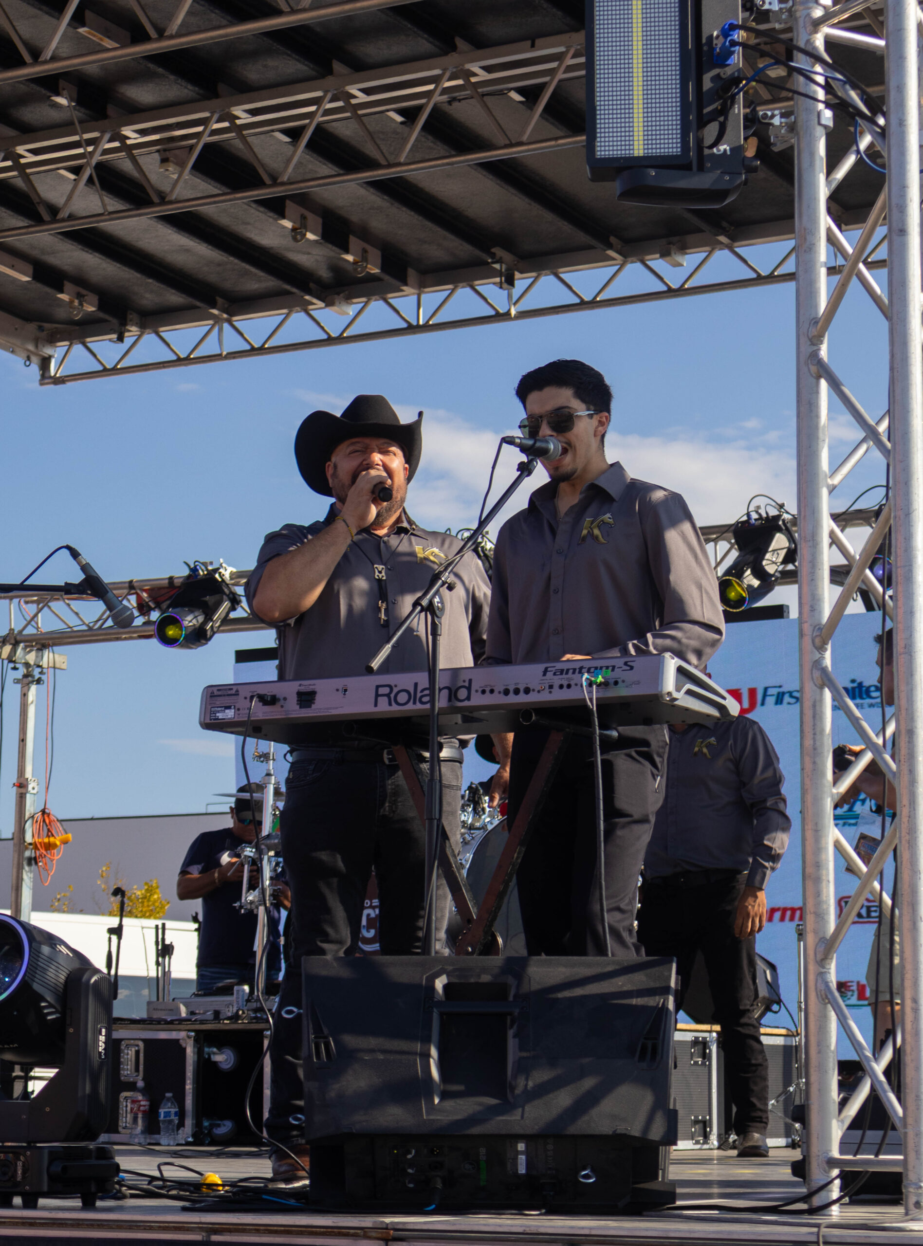 Two band members sing on stage. (Maycee Elerick/The Vista)