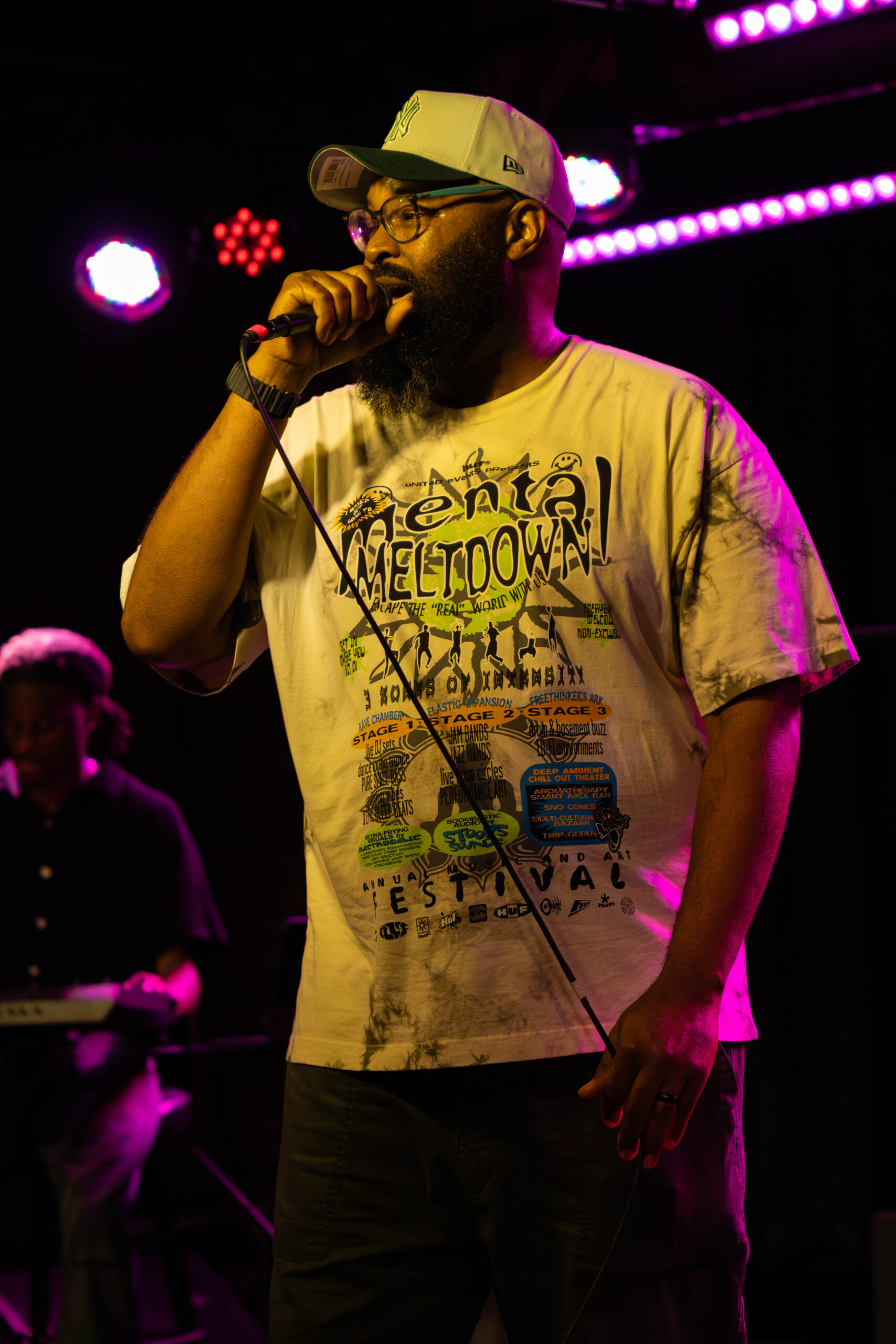 Tony Foster Jr. raps while holding microphone cord. (Maycee Elerick/The VIsta)