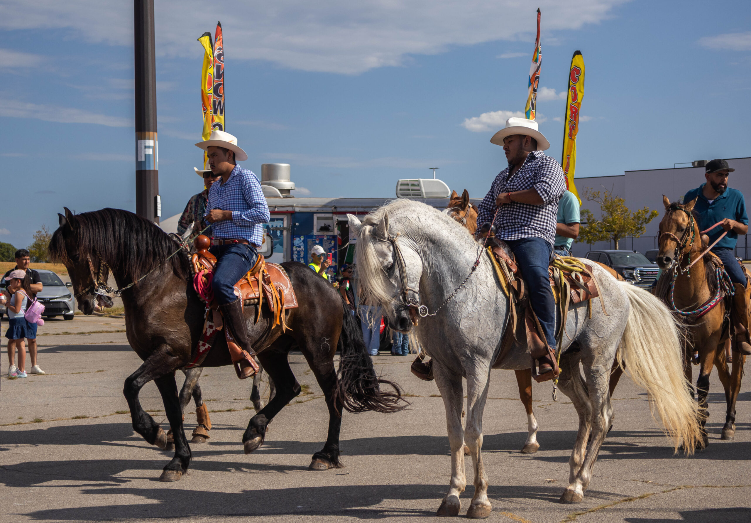 Two men dance with their horses in parade line. (Maycee Elerick/The Vista)