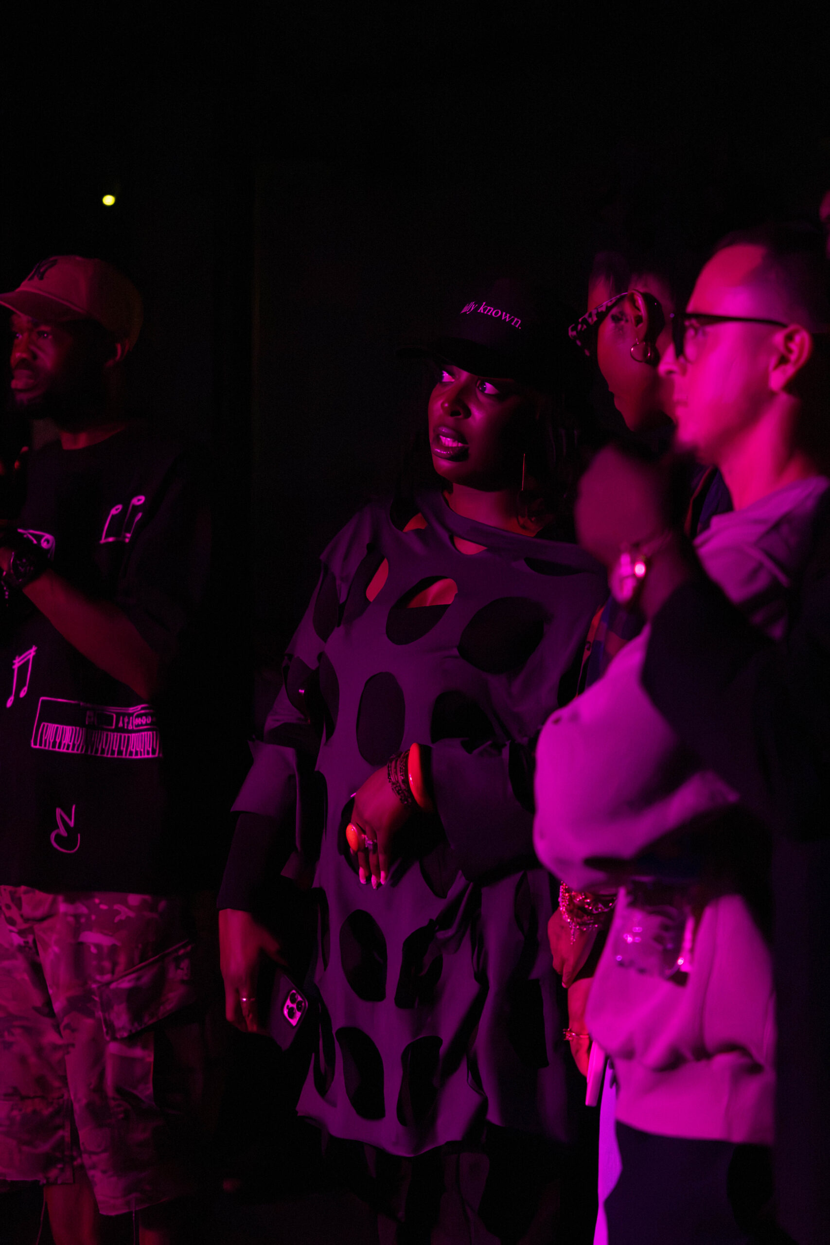 Crowd watches the stage covered in pink lighting. (Maycee Elerick/The Vista)