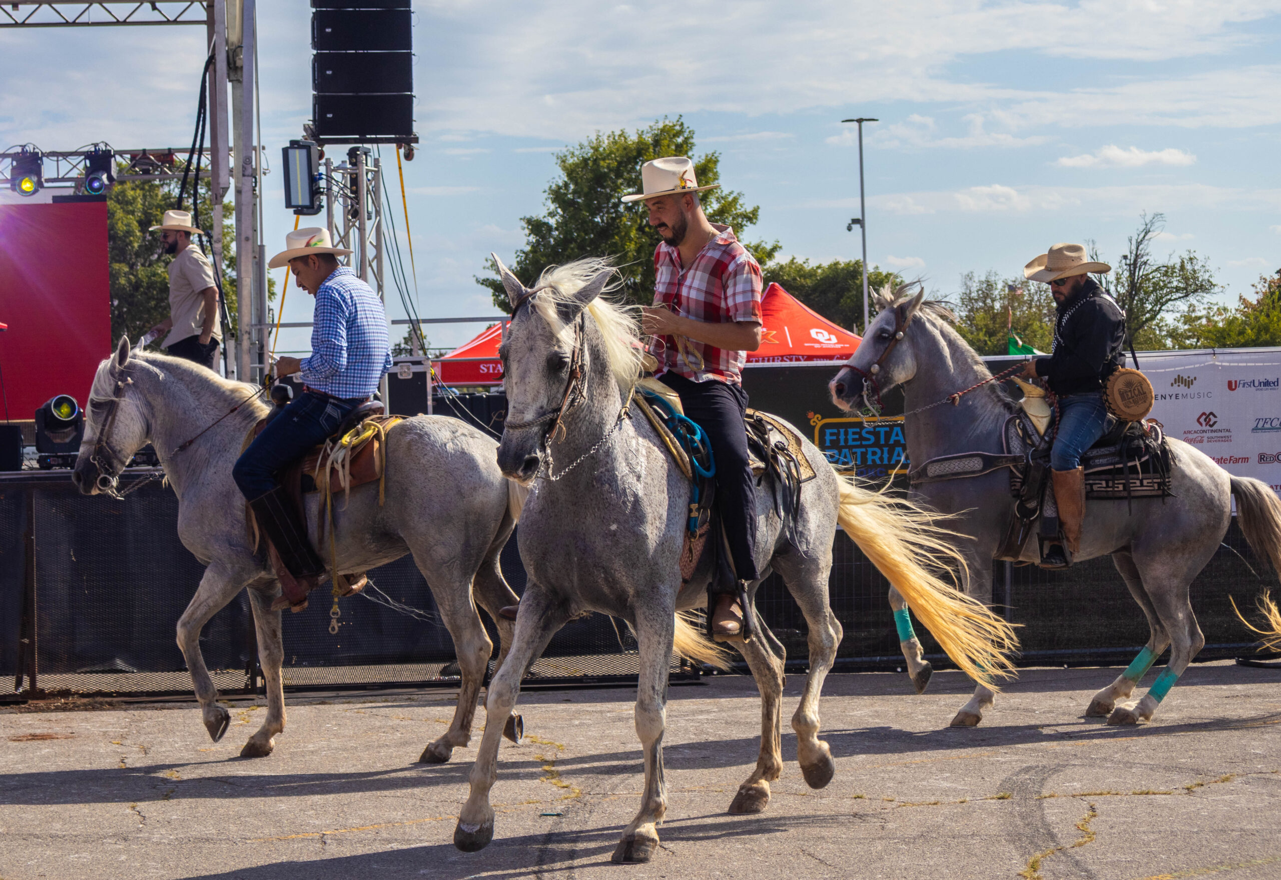 Three riders dance with horses in front of crowd. (Maycee Elerick/The Vista)