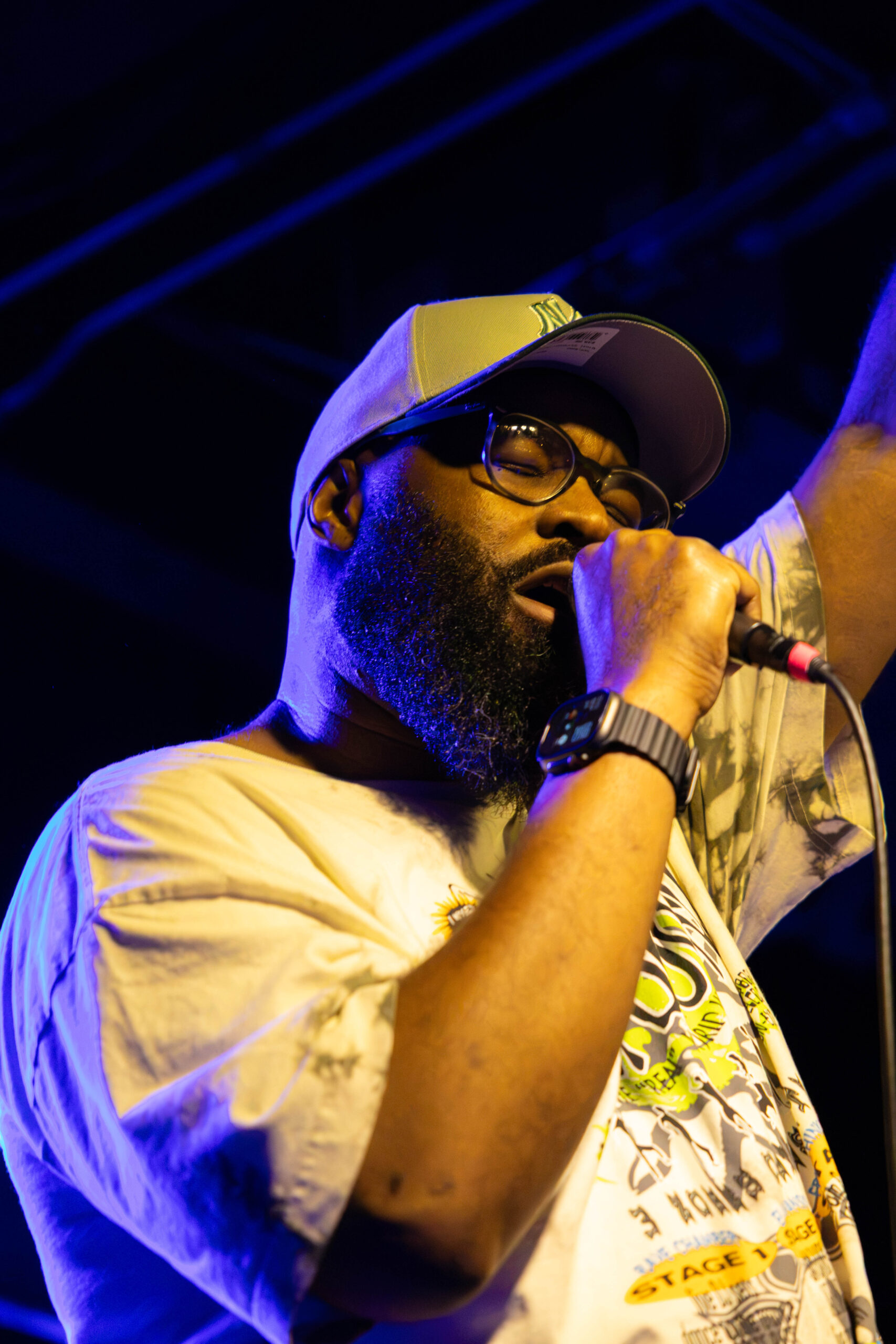 Tony Foster Jr. raises his arm up while preforming. (Maycee Elerick/The Vista)