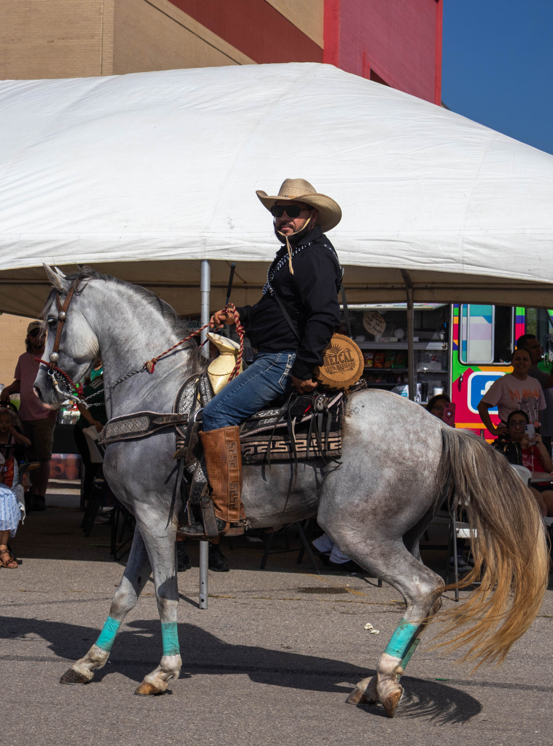 Man rides his horse in front of vendors. (Maycee Elerick/The Vista)