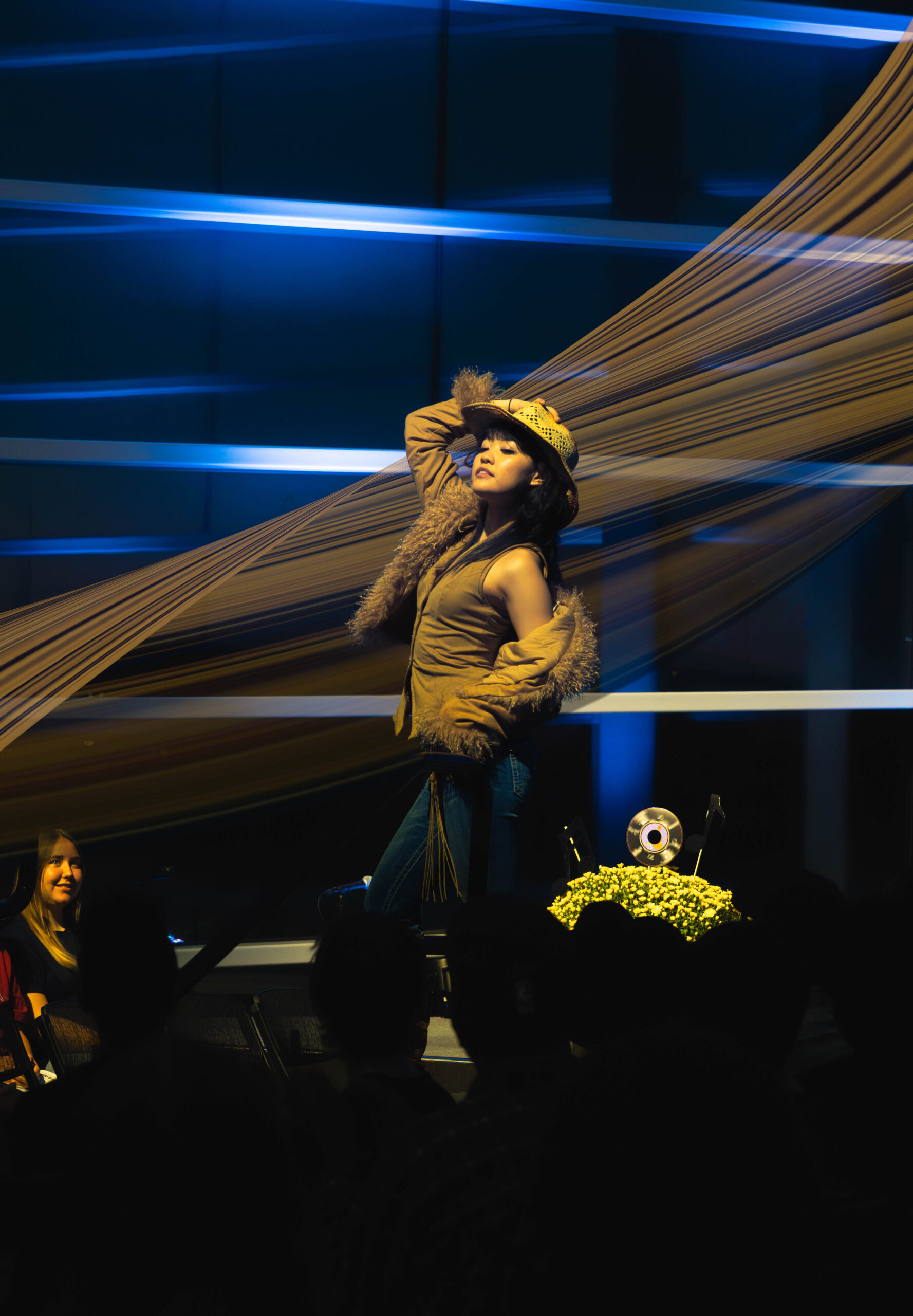 Model posses on stage grabbing her hat. (Maycee Elerick/The Vista)