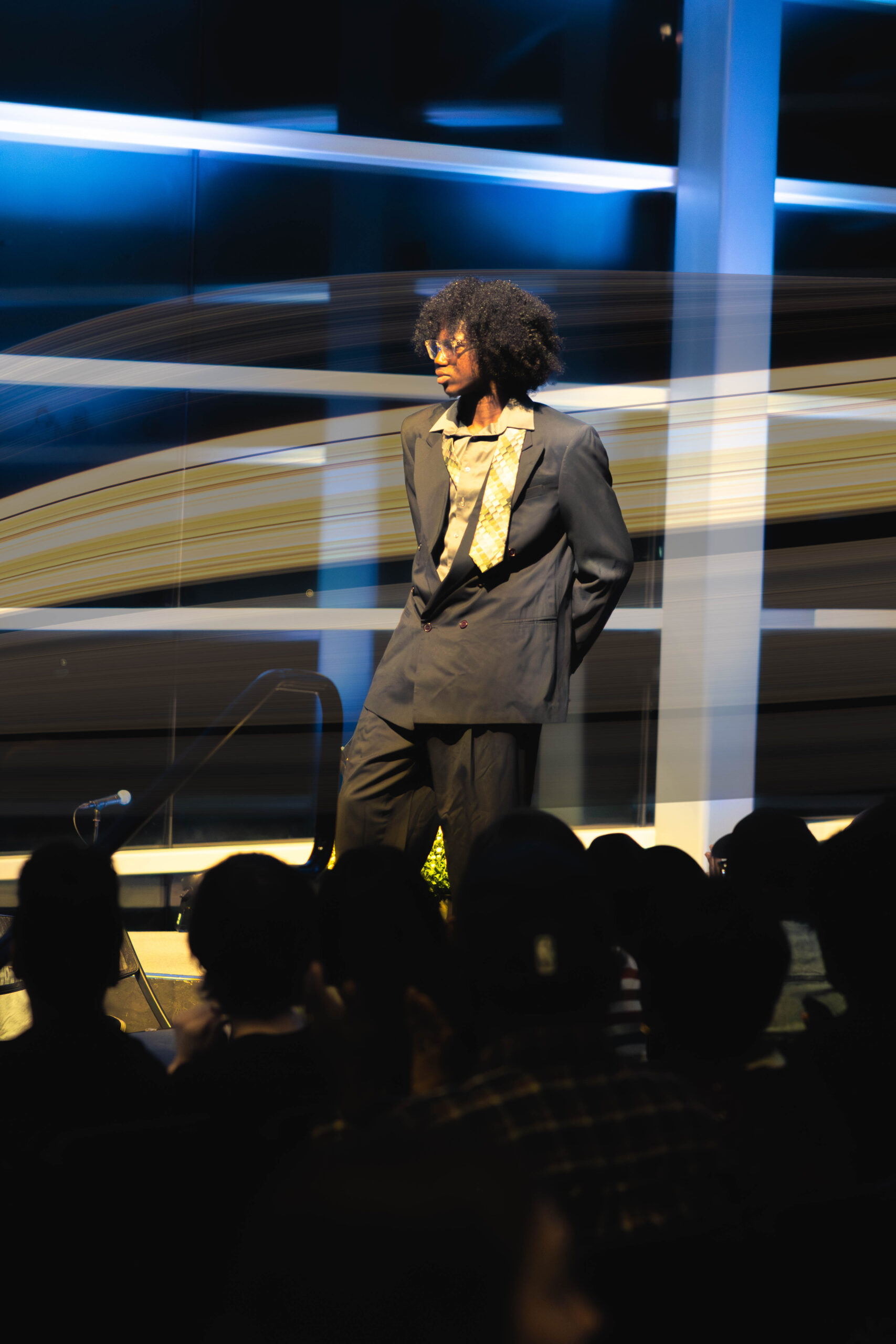 A model poses in a suit with a loose tie (Maycee Elerick/The Vista)