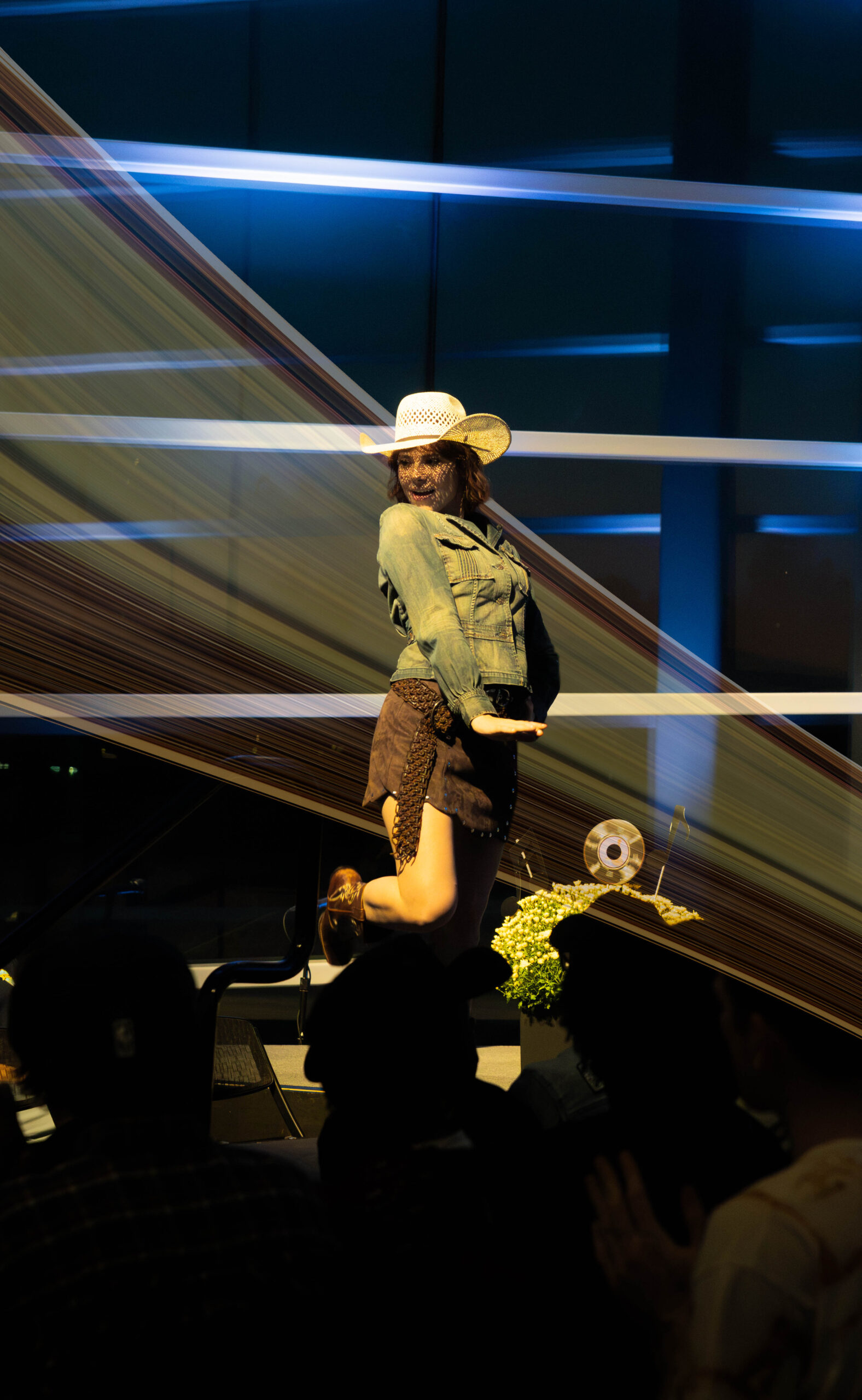 Model kicks her leg up and poses on stage. (Maycee Elerick/The Vista)