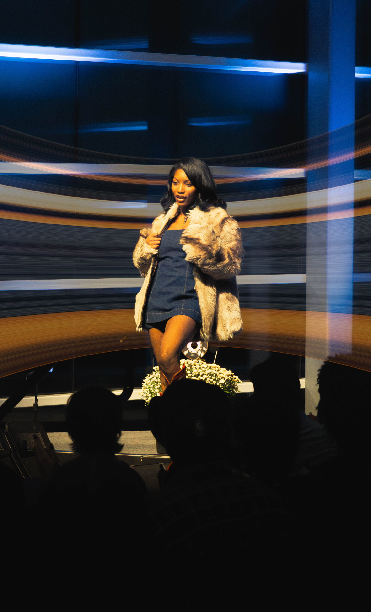 Model grabs her jacket on stage. (Maycee Elerick/The Vista)